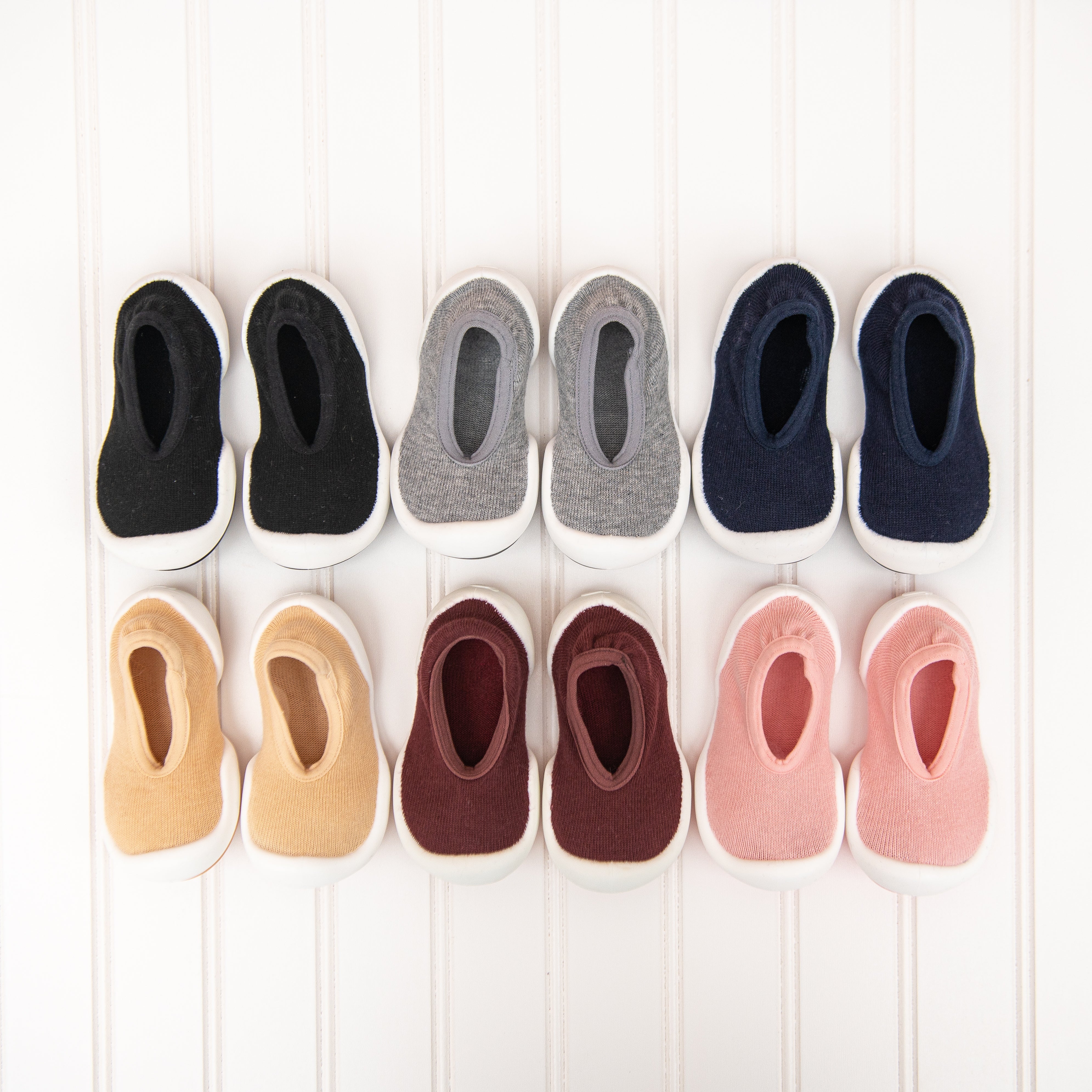 Ten baby shoes in various colors lined up in two rows.