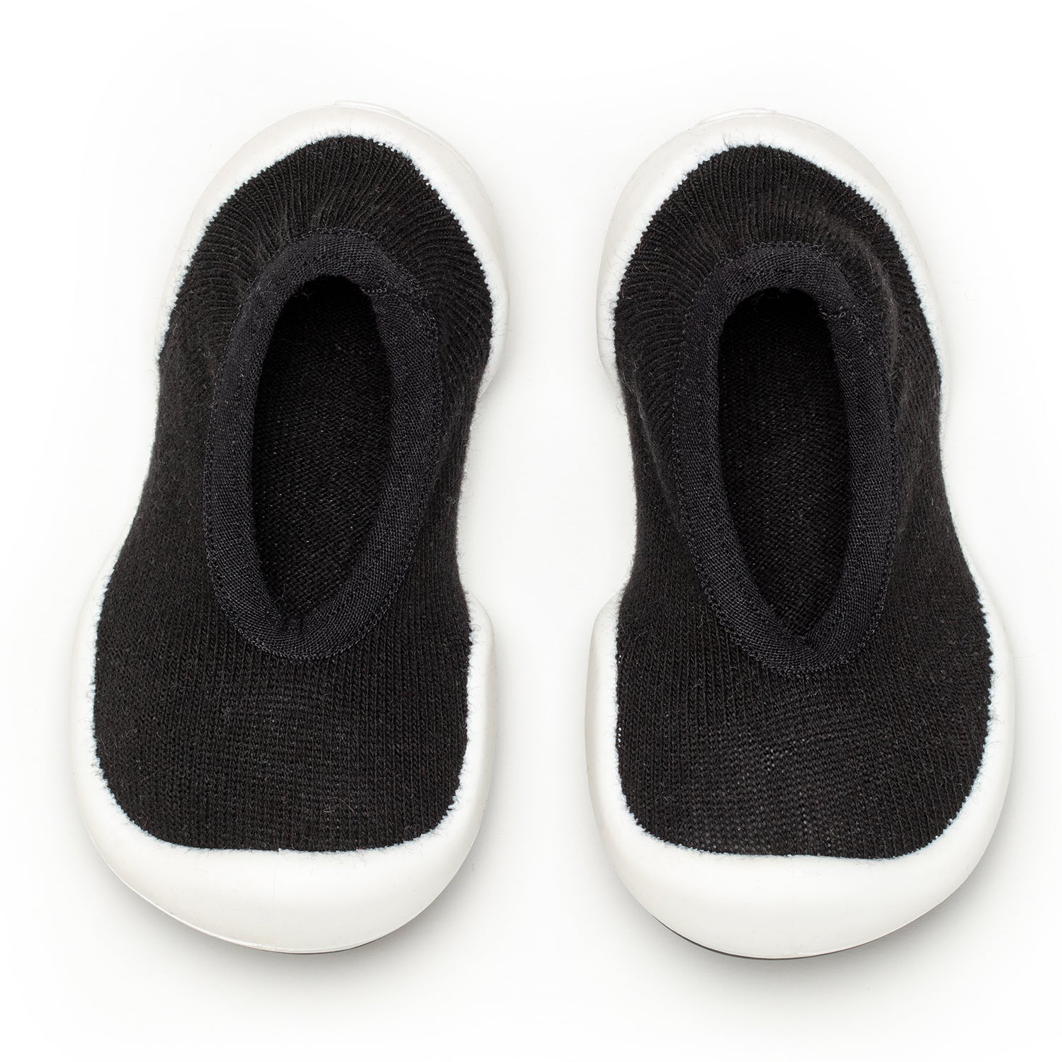 Two black knit baby shoes with white soles.