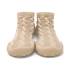 A pair of tan knit baby shoes with rubber soles.