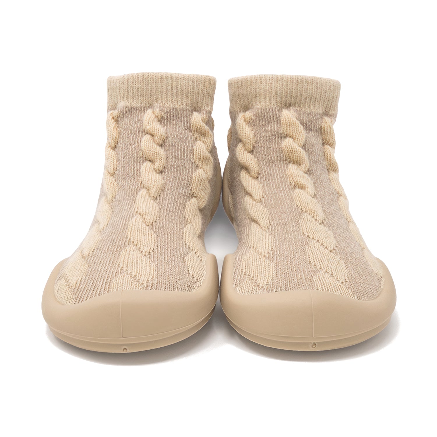 A pair of tan knit baby shoes with rubber soles.