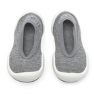 A pair of gray knit baby shoes with white soles.