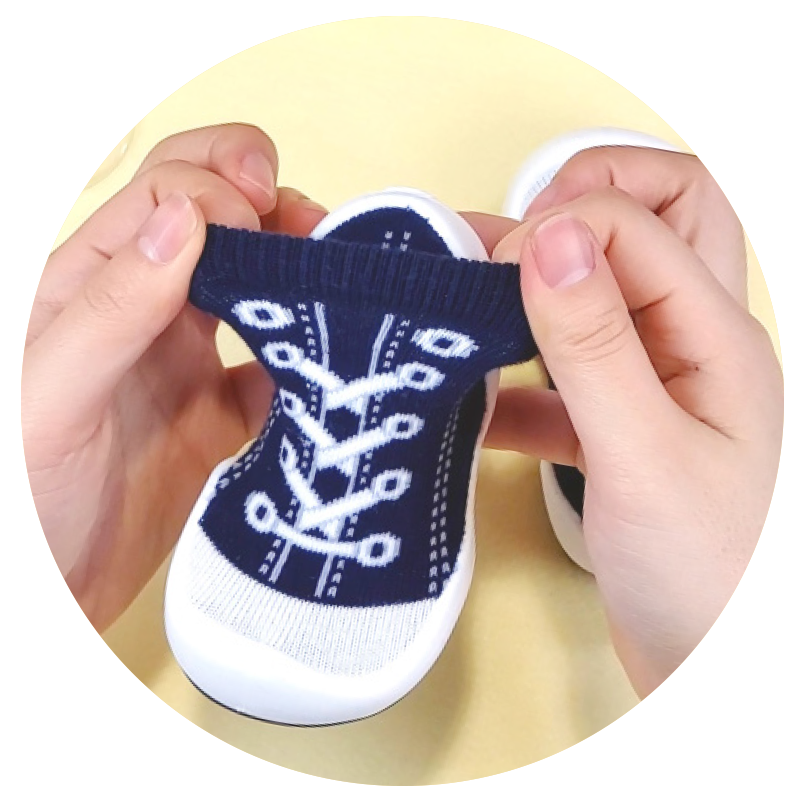 Close-up in Komuello navy Sneakers baby sock shoes on yellow background.