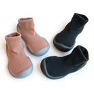 Two pairs of socks with gray soles, one pair black, one pair brown.