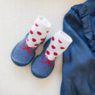 Still life of baby shoes and a denim shirt.