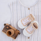Baby clothes, shoes, and wooden toy camera.