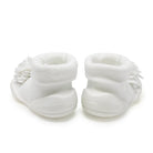 Two white baby shoes with flower detail, back view.
