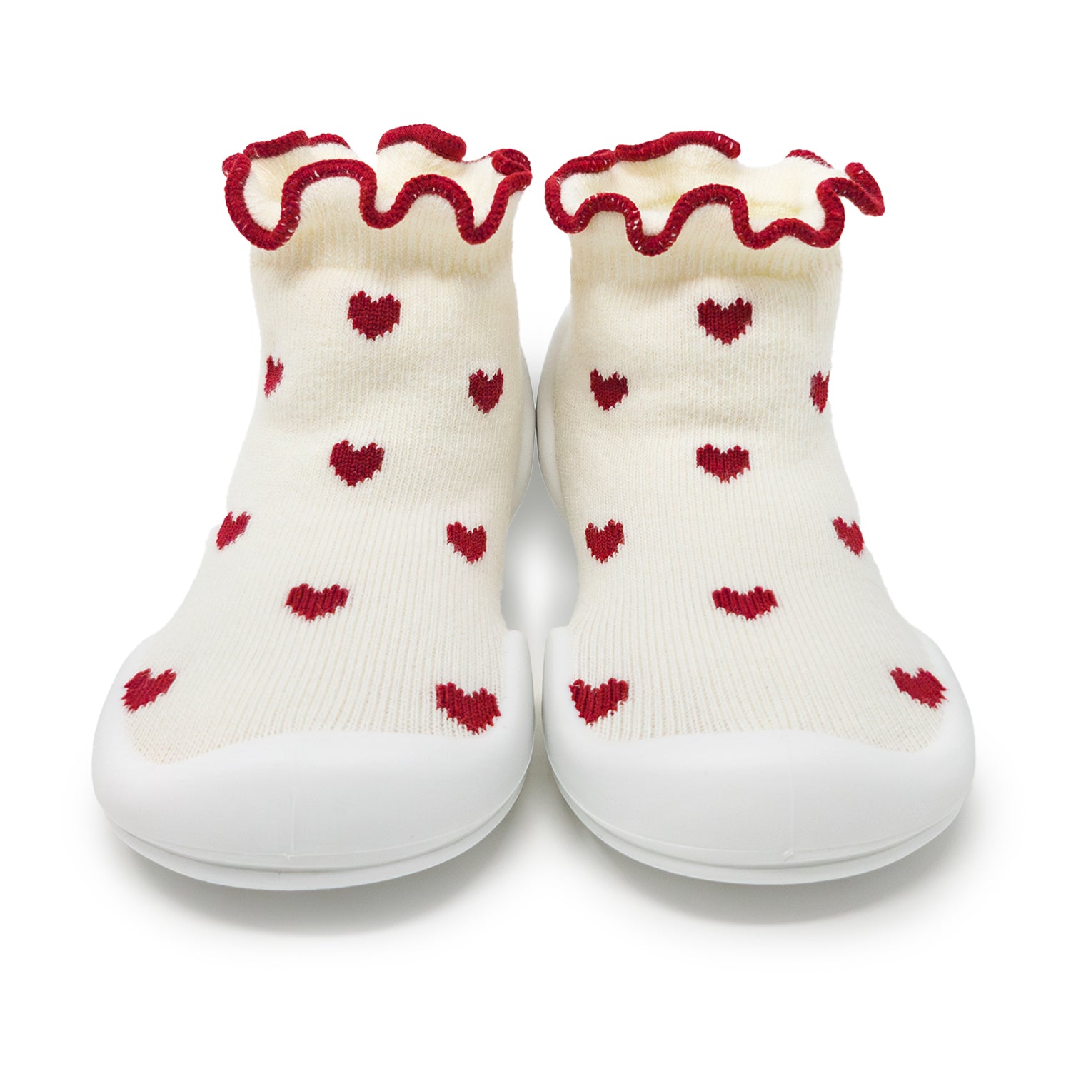 Two baby shoes with red heart pattern and ruffled red trim.