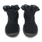 Two black baby sock shoes with ruffled lace tops.