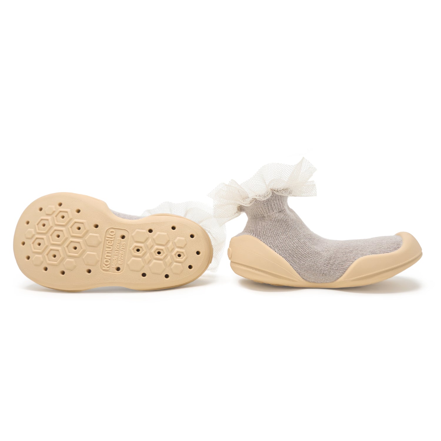A pair of beige and grey baby sock-shoes with tulle trim.