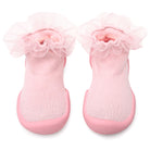 Pair of pink baby socks with lace trim and rubber soles.