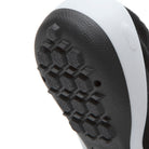 Close-up of a black shoe sole with a white stripe.