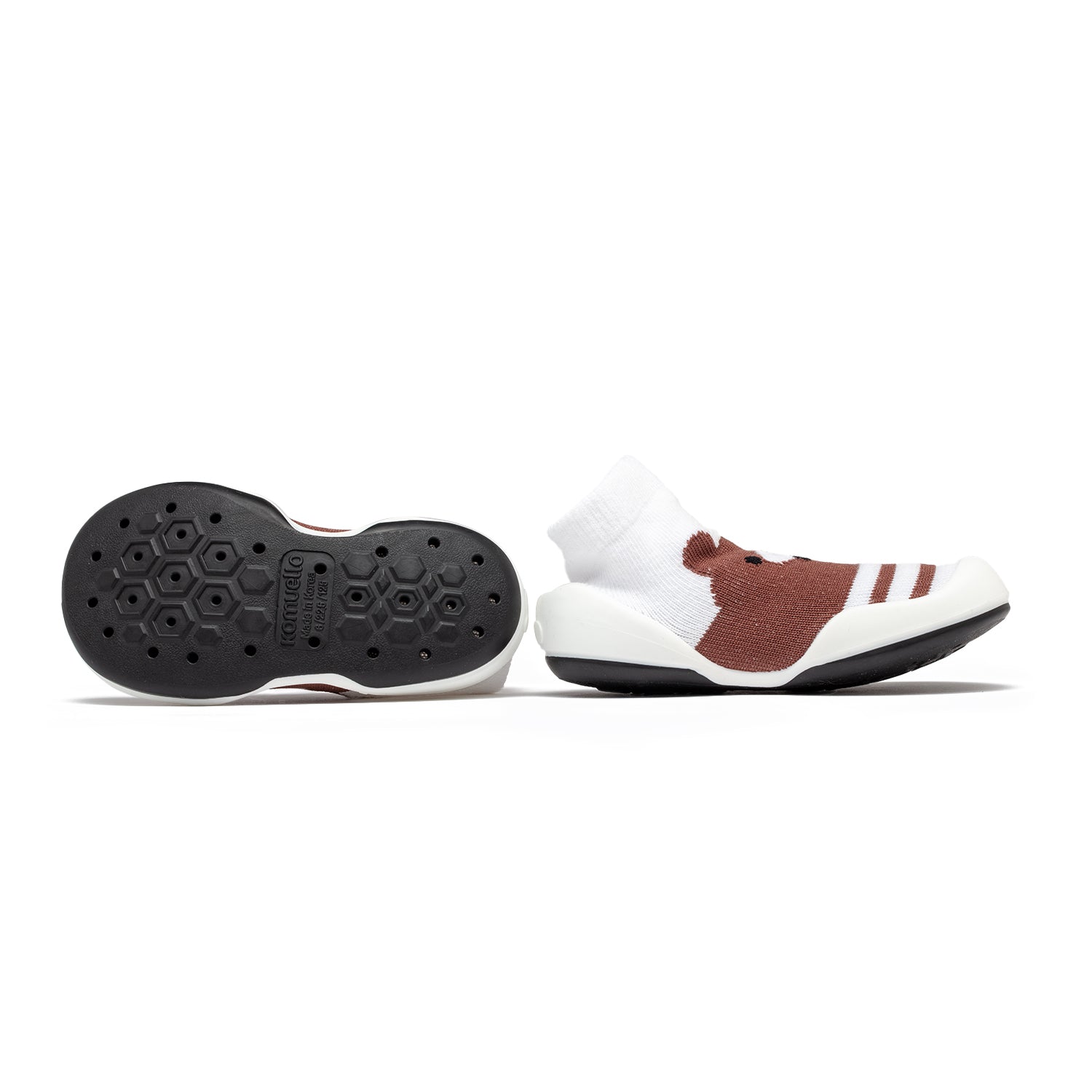 Two brown and white baby shoes, one showing the black sole.