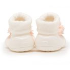 Two white baby booties with pink flower accents.