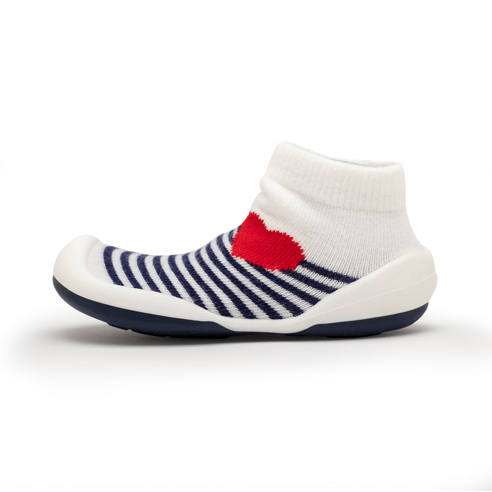 Child's sock shoe with white, navy stripes, and red heart.