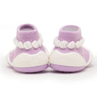 A pair of lilac-purple baby slipper-socks with white accents.