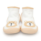 Two white sock shoes with a tan bear design and tan rubber soles.
