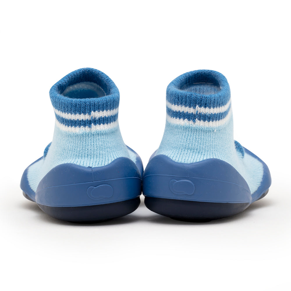 A pair of blue sock shoes on a white surface.