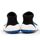 Two black and white baby shoe socks with blue soles.