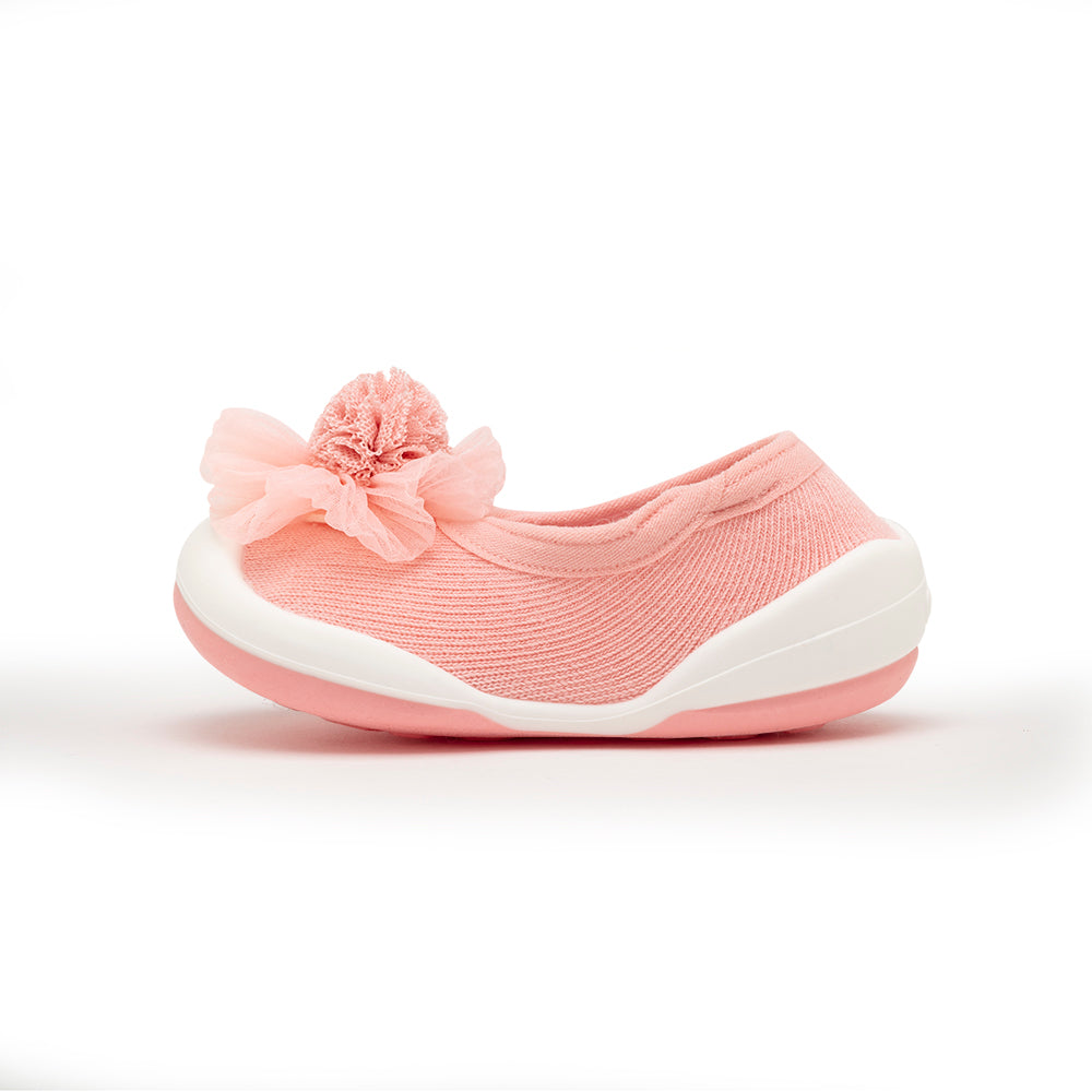 A pink slipper with a white sole and a pink flower on top.
