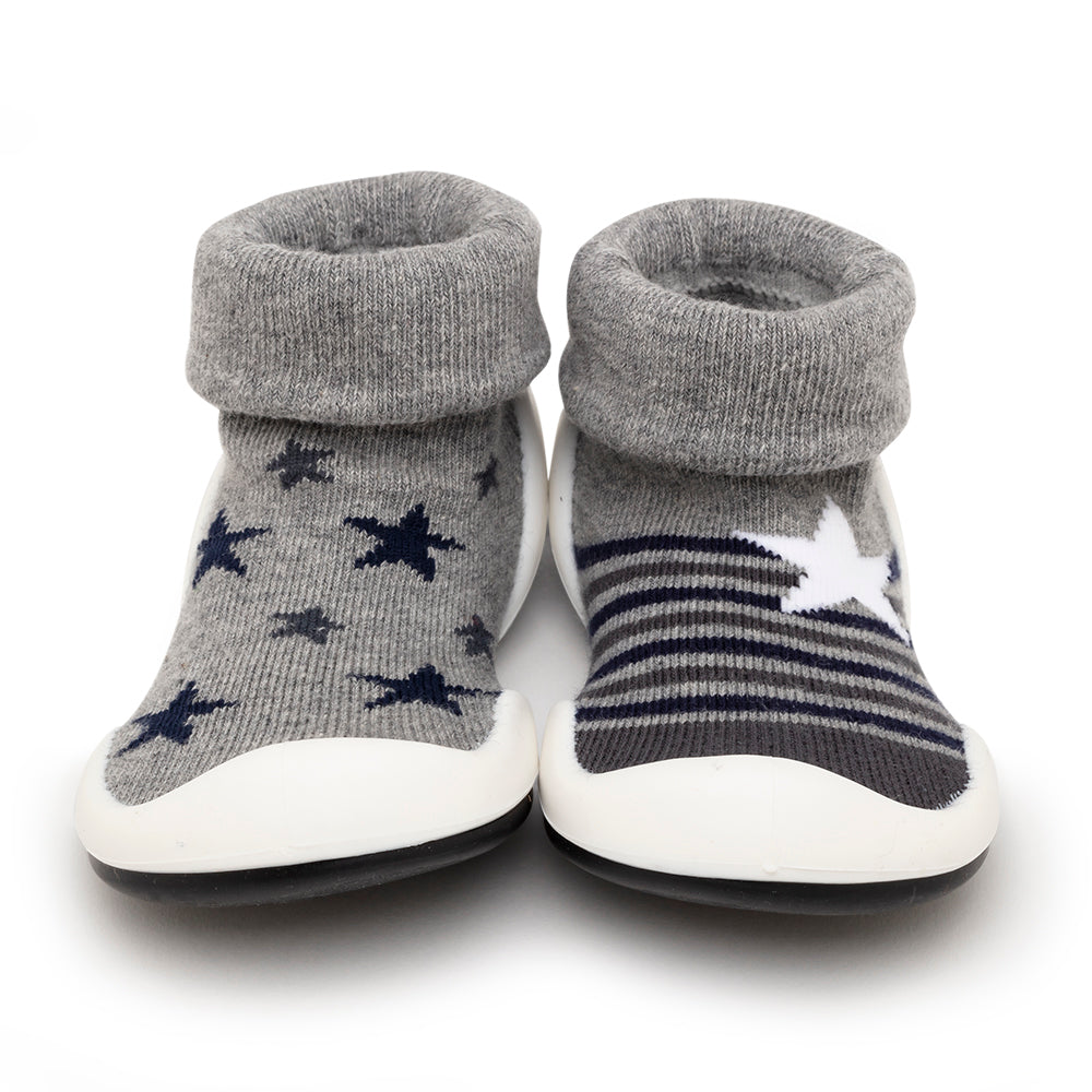 Two baby sock shoes, one with navy stars and one with navy stripes, on a white background.