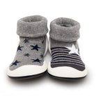Two baby sock shoes, one with navy stars and one with navy stripes, on a white background.