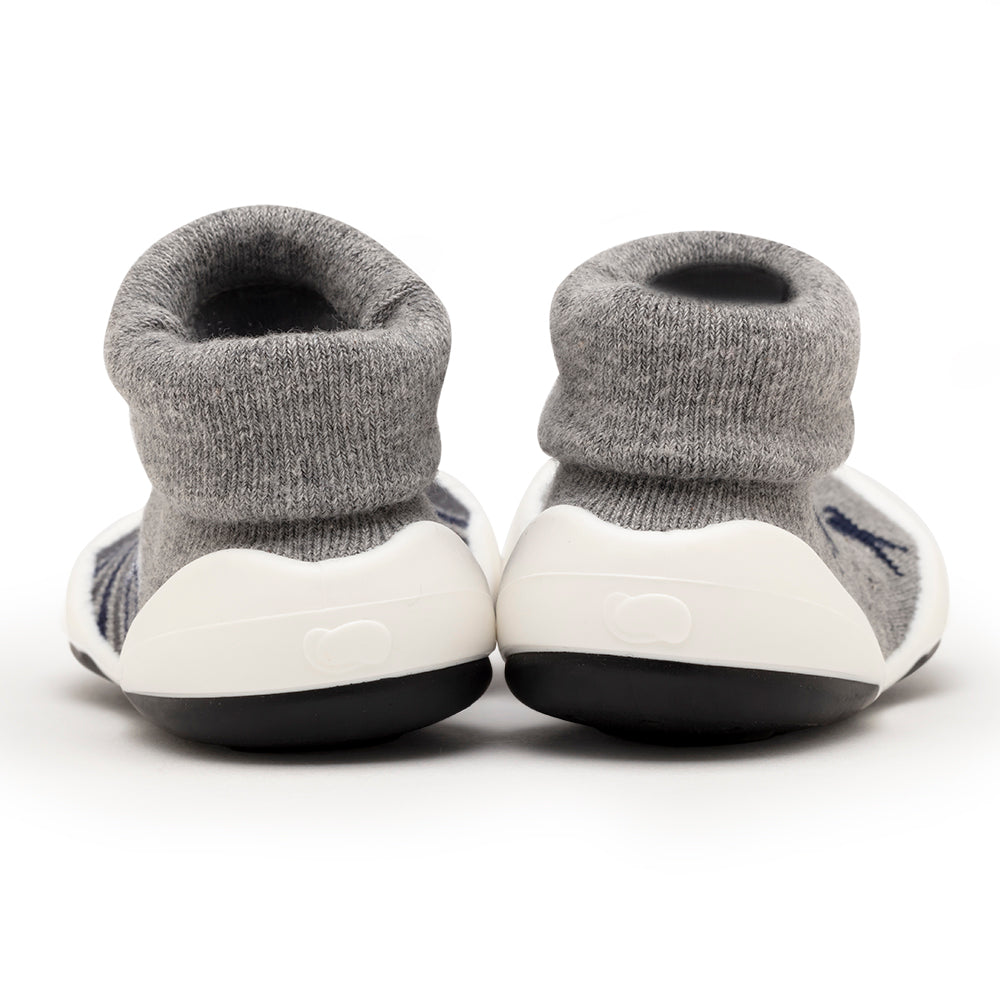 Two grey sock shoes, back view, white soles, black bottom.