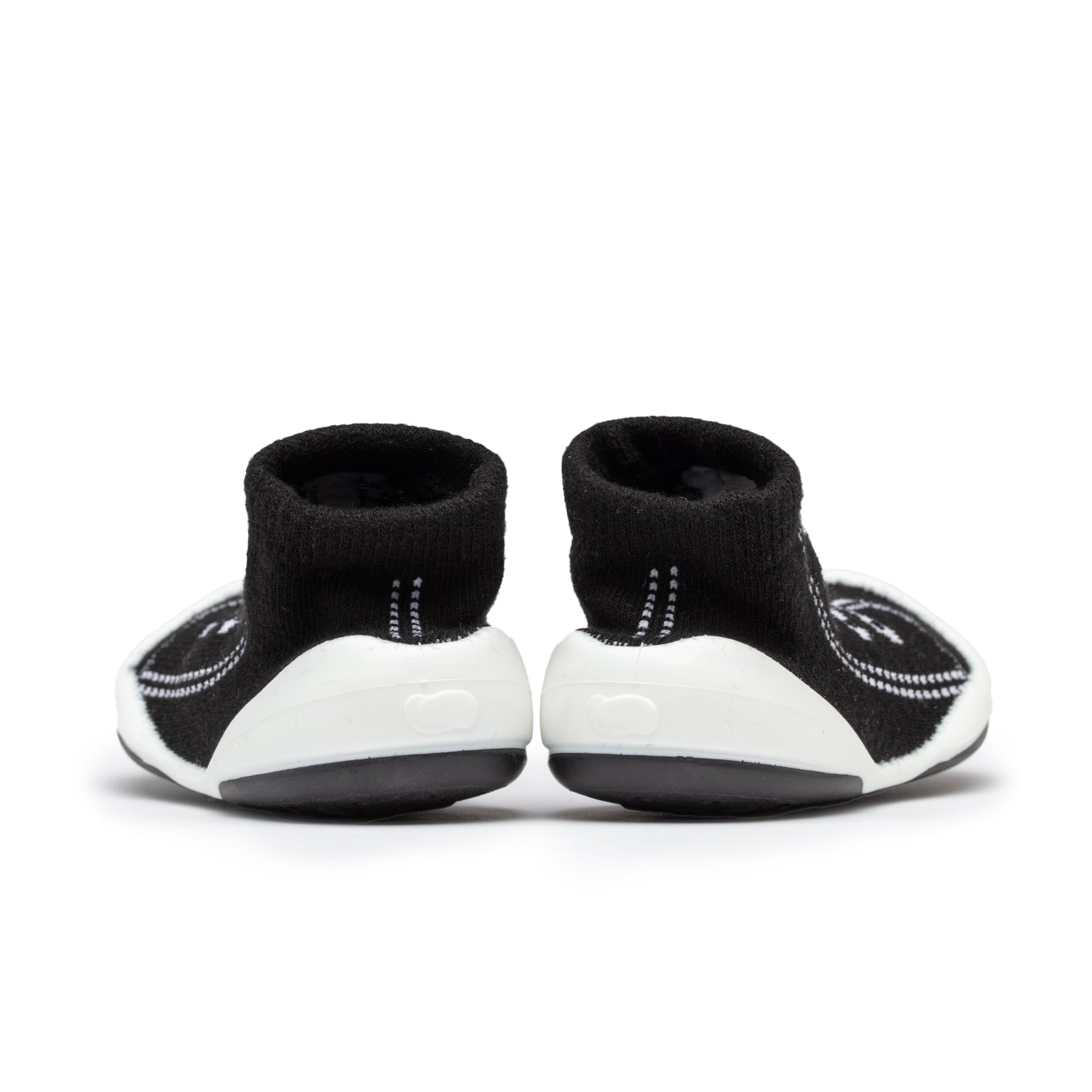 Pair of black and white baby sock shoes.