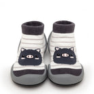 Two gray and white striped baby shoes with a pig design.