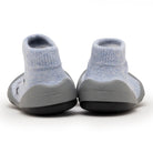 A pair of blue sock shoes with gray soles.