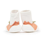 Back view of baby sock shoes with white socks, peach colored fabric, and white soles.