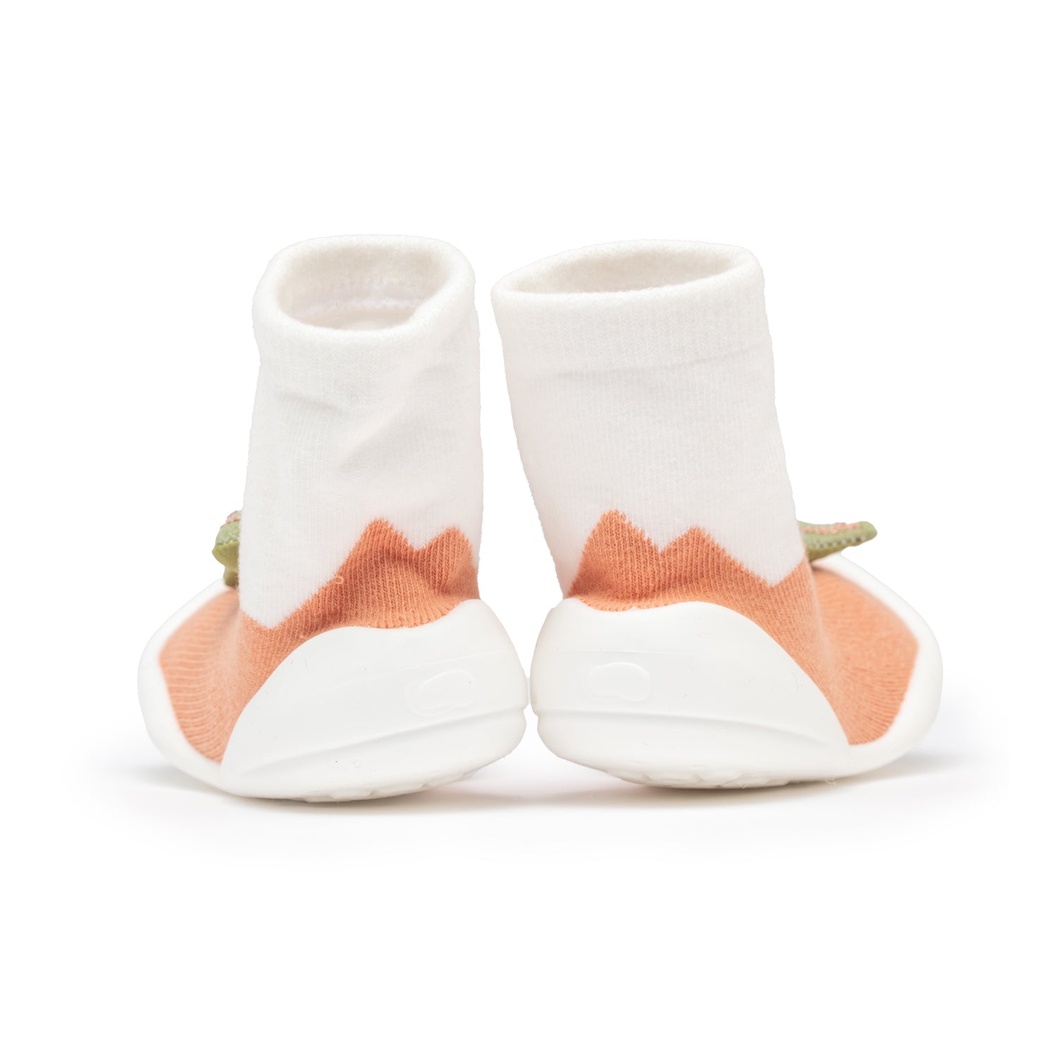 Back view of baby sock shoes with white socks, peach colored fabric, and white soles.