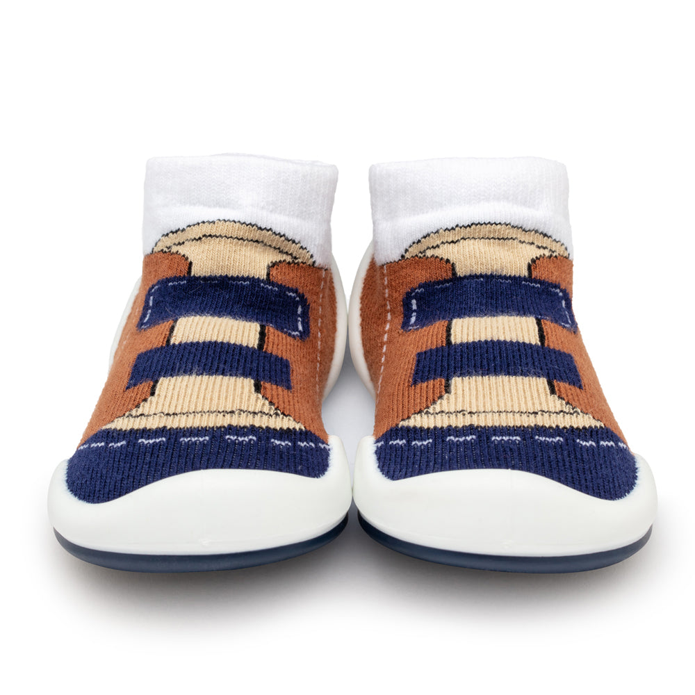 Two baby shoe socks, front view, white cuffs, brown, blue, and tan knit pattern, white and blue soles.