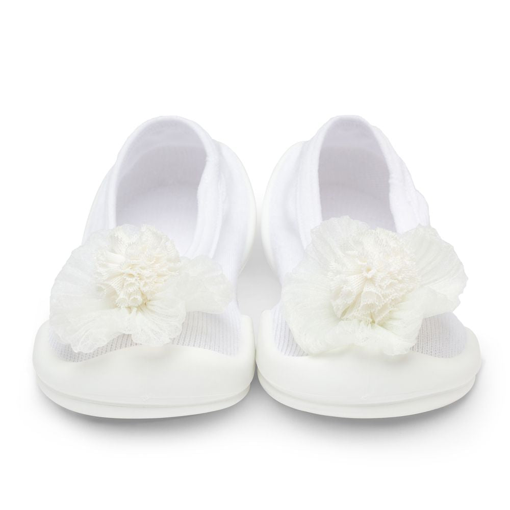 Two white baby shoes with chiffon flower accents.