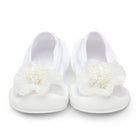 Two white baby shoes with chiffon flower accents.