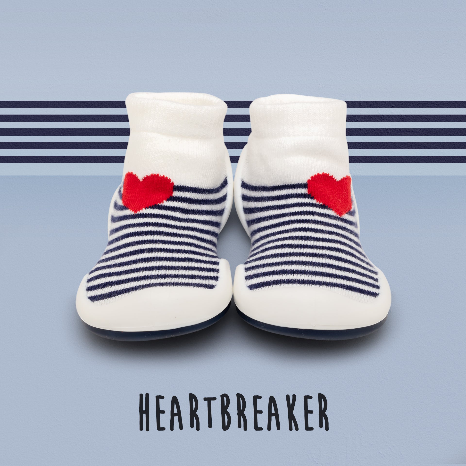 Two baby shoes with white tops, blue stripes, and red hearts.