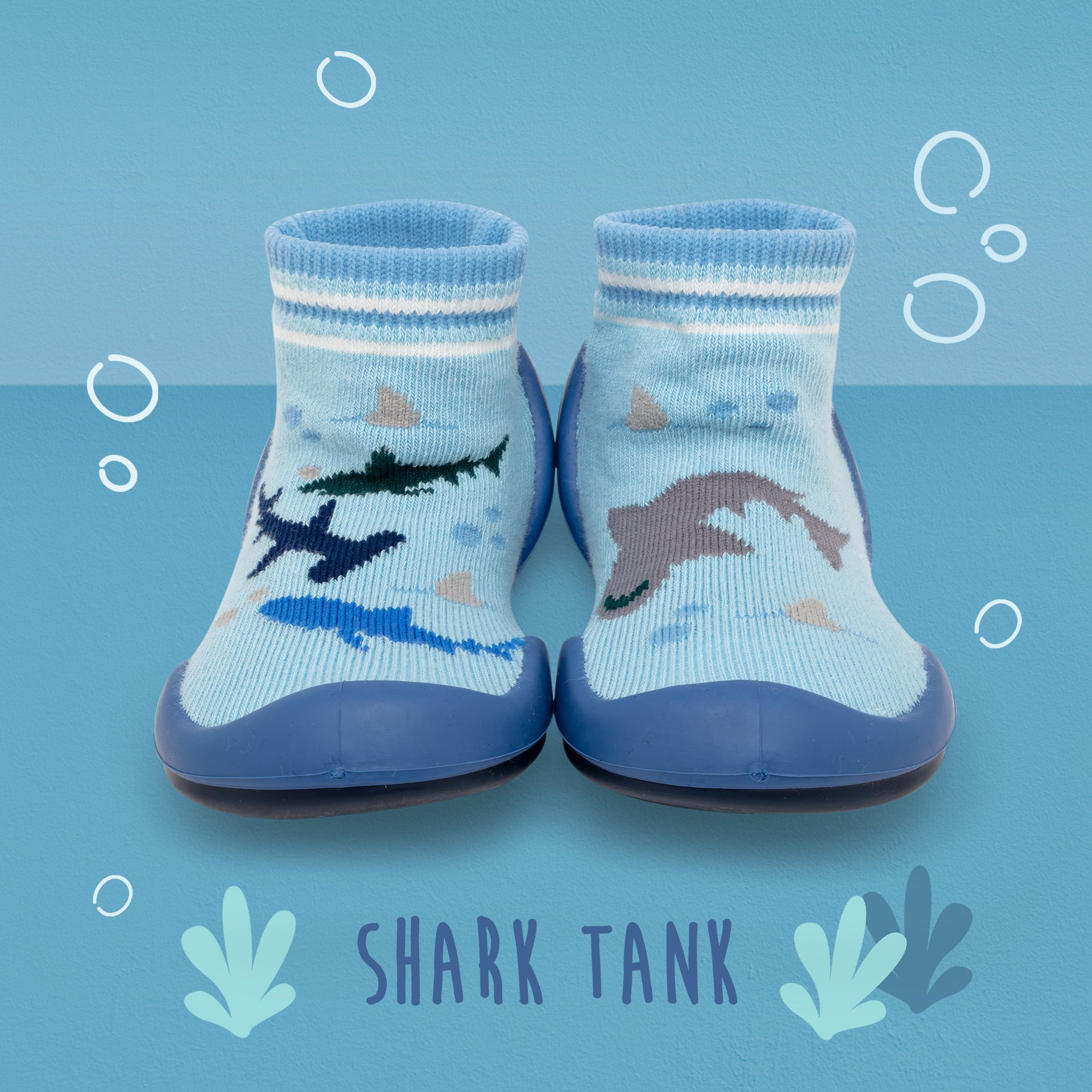 Two blue and white sock-shoes with shark designs.