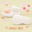 White baby sock shoes with flower embellishment.