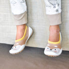 A child's feet wearing fox-themed slipper socks.