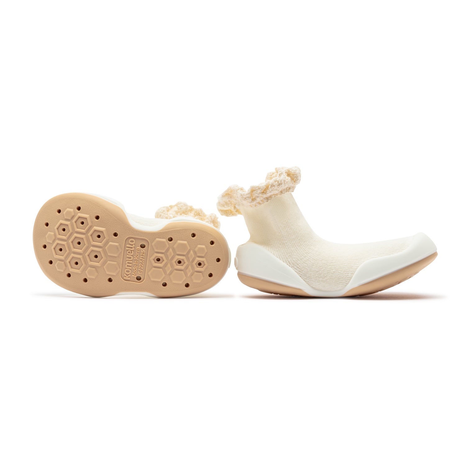 Two baby shoes; ivory sock-like upper with beige soles.