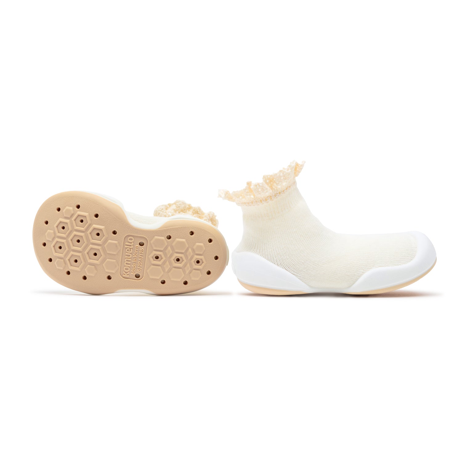 Two baby shoes; ivory sock-like upper with beige soles.
