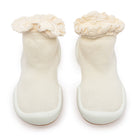 Pair of cream-colored sock-shoes with ruffled tops and grippy soles.
