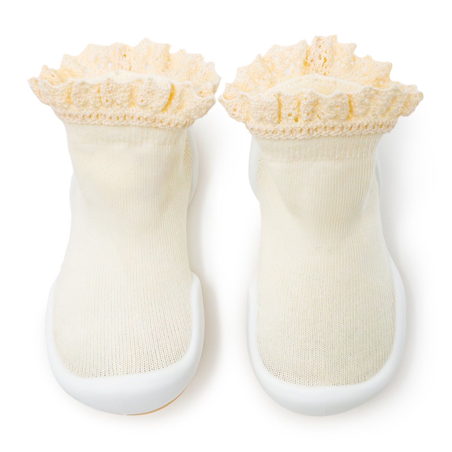 Pair of cream-colored sock-shoes with ruffled tops and grippy soles.