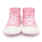 Pair of pink baby slipper socks with white laces and soles.