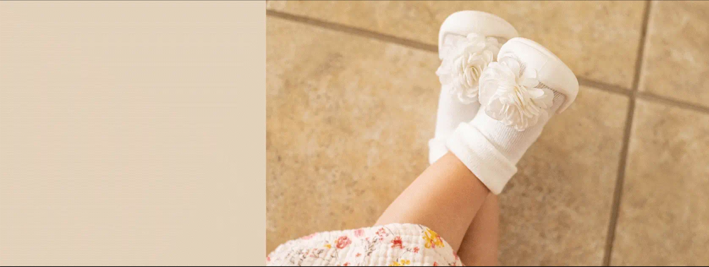White Komuello sock shoes with floral corsage on a tiled floor