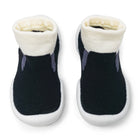Two black baby slipper socks with white cuffs and soles.