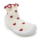 Baby sock shoe with red heart pattern and ruffled red trim.

