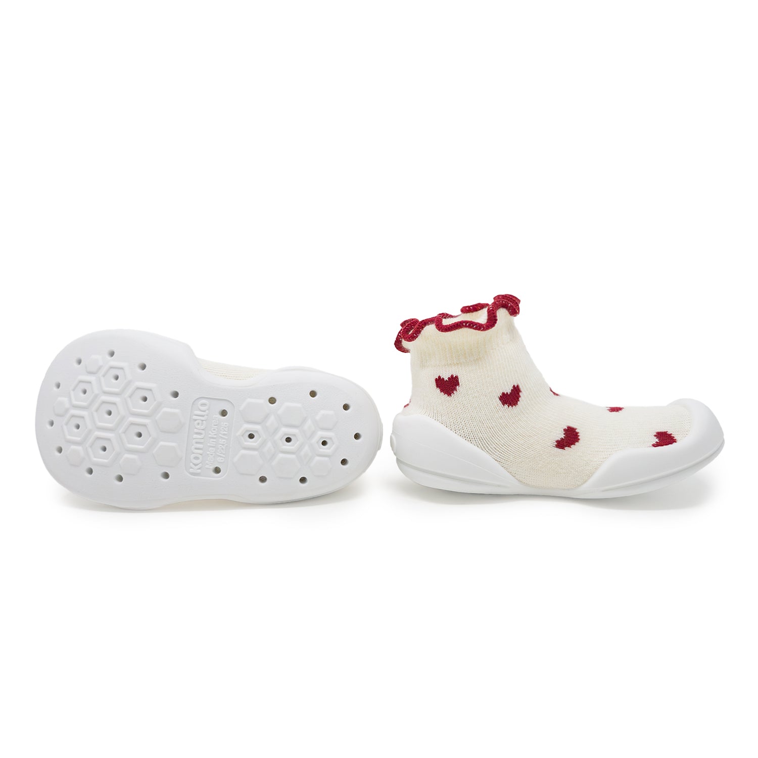 Pair of cream-colored baby shoes with red hearts and ruffles.